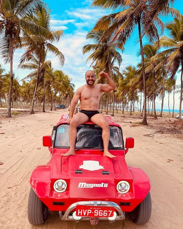 Viajante aproveita passeio de buggy sob coqueiros